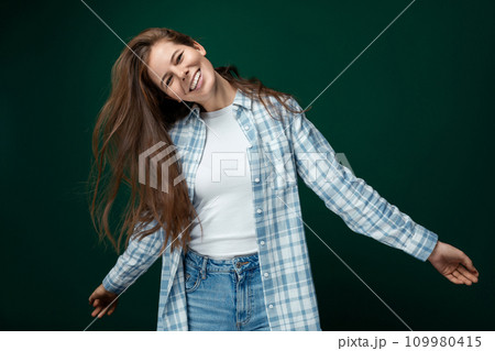 Portrait of a well-groomed young lady straightening her natural brown hair Portrait of a well-groomed young lady straightening her natural brown hair 109980415
