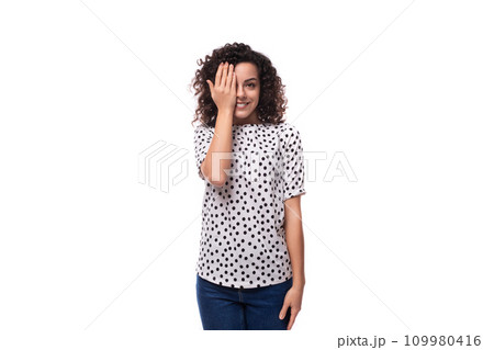 young stylish woman with curly hair dressed in a blouse with polka dots smiles and feels happy young stylish woman with curly hair dressed in a blouse with polka dots smiles and feels happy 109980416