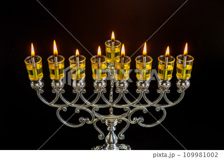 Traditional religious symbol of Hanukkah, depicting Hanukkiah menorah with candles burning 109981002