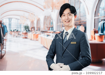 高級ブランド店で接客をする男性スタッフ 109982217