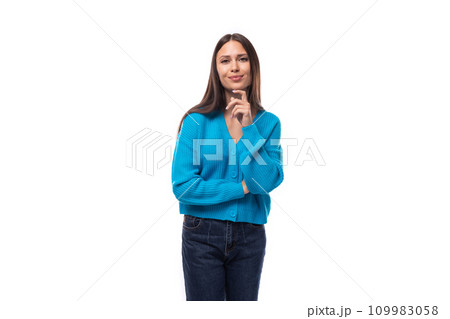 portrait of a young beautiful slim brunette woman dressed in a blue cardigan on a white background 109983058
