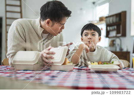 デリバリー・テイクアウトのハンバーガーとポテトを食べる父子 デリバリー・テイクアウトのハンバーガーとポテトを食べる父子 109983722