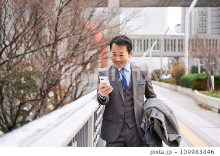 スマートフォンを見て喜ぶ男性 109983846