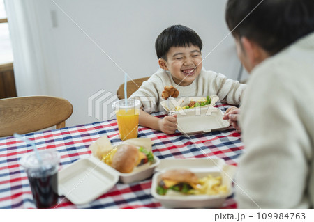 ハンバーガーを食べる親子 30代の父親と小学1年生の息子 ハンバーガーを食べる親子 30代の父親と小学1年生の息子 109984763