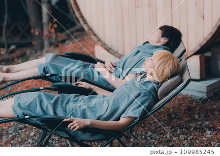 サウナに入り外でくつろぐカップル 109985245