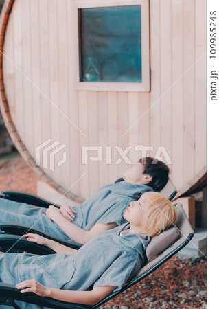 サウナに入り外でくつろぐカップル サウナに入り外でくつろぐカップル 109985248
