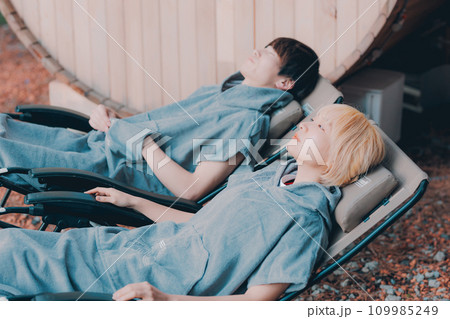 サウナに入り外でくつろぐカップル 109985249