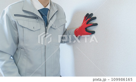 壁紙を点検する作業服の男性｜リフォーム調査・見積り　イメージ 109986165