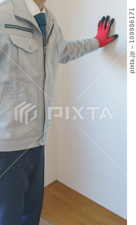 壁紙を点検する作業服の男性｜リフォーム調査・見積り　イメージ 109986171