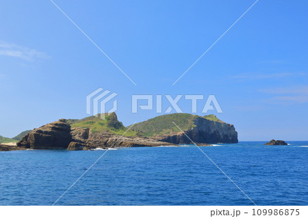 青い海から岩壁が垂直にそびえる壱岐辰ノ島の海岸線の景色 109986875