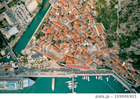 Port with moored yachts and a huge cruise ship. Kotor, Montenegro. Top view Port with moored yachts and a huge cruise ship. Kotor, Montenegro. Top view 109986903