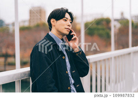 橋の上で電話をする男性 橋の上で電話をする男性 109987832