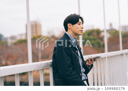橋の上でスマホを見る男性 橋の上でスマホを見る男性 109988179