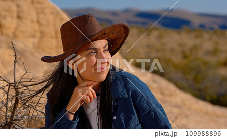 Portrait shot of a young cowgirl wearing a cowboy hat posing for the camera Portrait shot of a young cowgirl wearing a cowboy hat posing for the camera 109988896
