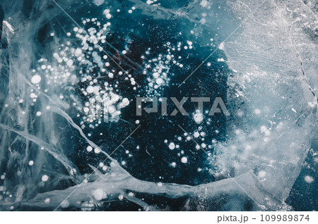 Beautiful cracks surface of the frozen lake of Baikal lake with frost methane bubbles in winter season. Baikal is the largest freshwater lake and the world's deepest lake. Beautiful cracks surface of the frozen lake of Baikal lake with frost methane bubbles in winter season. Baikal is the largest freshwater lake and the world's deepest lake. 109989874