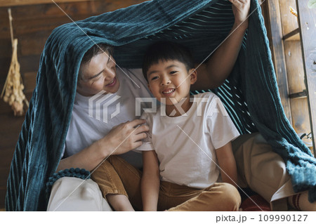 毛布にくるまった笑顔の親子　30代の父親と7歳の息子 109990127