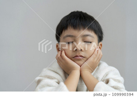 目を閉じて考えごとをする男の子 目を閉じて考えごとをする男の子 109990394
