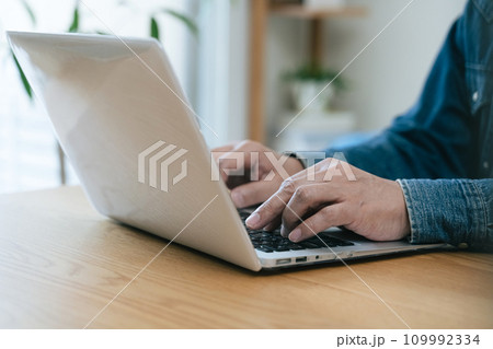 自宅でパソコンを操作するミドル男性 109992334