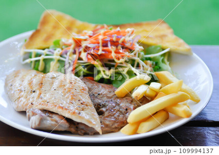 pork steak and chicken steak with French fries ,bread and salad or grilled pork and grilled chicken with fried potato 109994137