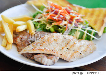 pork steak and chicken steak with French fries ,bread and salad or grilled pork and grilled chicken with fried potato pork steak and chicken steak with French fries ,bread and salad or grilled pork and grilled chicken with fried potato 109994138