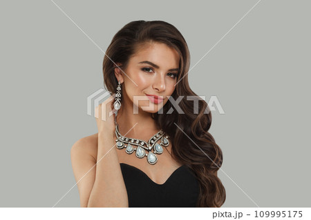 Gorgeous glamorous woman jewelry model with diamonds posing on gray background Gorgeous glamorous woman jewelry model with diamonds posing on gray background 109995175