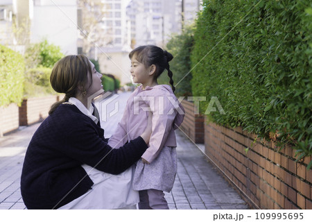 遊歩道で4歳の女の子と向かい合わせに座って話をする若い茶髪のママ 遊歩道で4歳の女の子と向かい合わせに座って話をする若い茶髪のママ 109995695