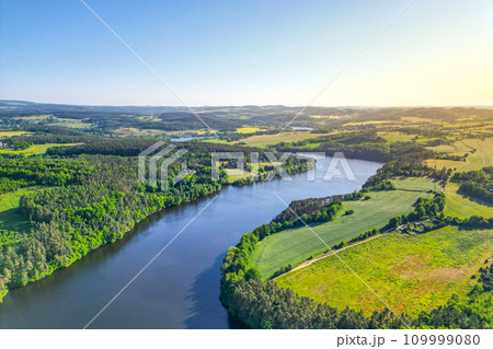 Curves of Vltava river in green landscape on sunny summer day. Aerial drone view. Curves of Vltava river in green landscape on sunny summer day. Aerial drone view. 109999080