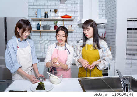 キッチンでおにぎりを作る3人の女性 キッチンでおにぎりを作る3人の女性 110000343