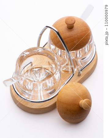 Opened glass jar with salt or sugar. Standing on wooden table Opened glass jar with salt or sugar. Standing on wooden table 110000979