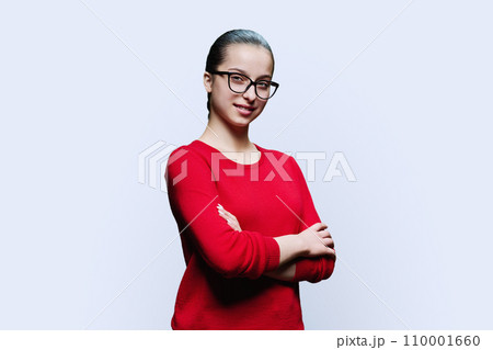 Portrait of confident smiling teenager girl in red on white background Portrait of confident smiling teenager girl in red on white background 110001660