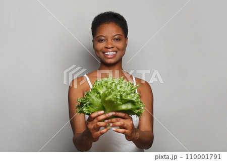 Cheerful woman holding vegetable green lettuce on white background. Healthy lifestyle Cheerful woman holding vegetable green lettuce on white background. Healthy lifestyle 110001791