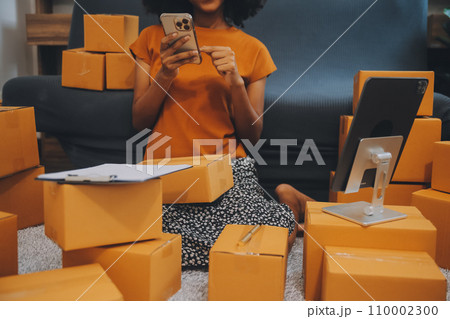 Startup SME small business entrepreneur of freelance Asian woman using a laptop with box Cheerful success happy Asian woman her hand lifts up online marketing packaging and delivery SME idea concept 110002300