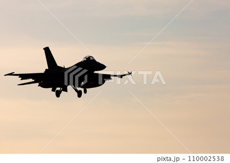 夕日を浴びて映画のような着陸するF-2戦闘機のシルエット 110002538