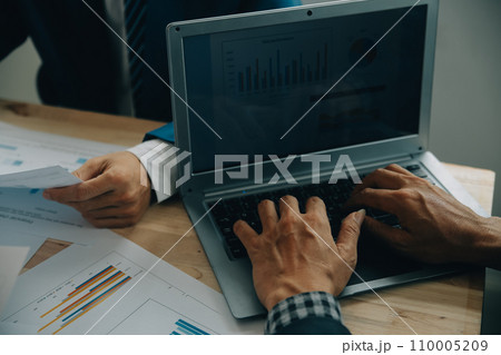 Financial analysts analyze business financial reports on a digital tablet planning investment project during a discussion at a meeting of corporate showing the results of their successful teamwork. 110005209