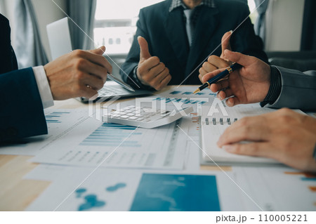 Financial analysts analyze business financial reports on a digital tablet planning investment project during a discussion at a meeting of corporate showing the results of their successful teamwork. 110005221