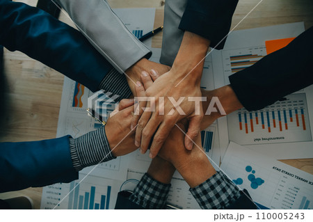 Financial analysts analyze business financial reports on a digital tablet planning investment project during a discussion at a meeting of corporate showing the results of their successful teamwork. 110005243