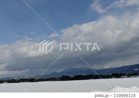 青い空の下で山を覆う巨大な雲を見ている風景 110006118