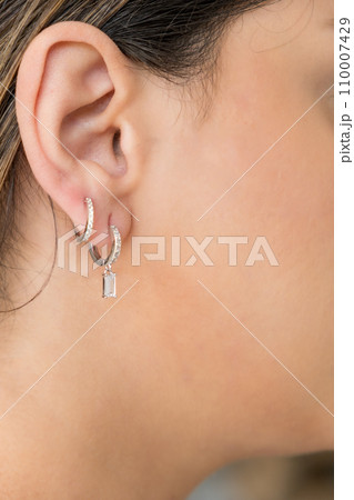 Young woman wearing silver clear sweet drop earrings. Young woman wearing silver clear sweet drop earrings. 110007429