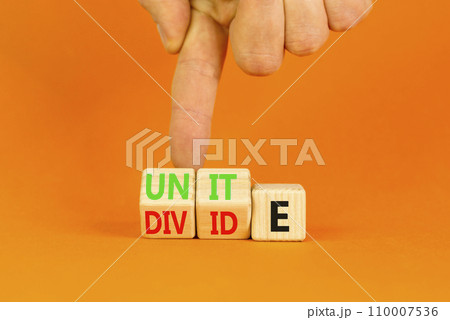 Unite or divide symbol. Concept word Unite or Divide on wooden cubes. Beautiful orange table orange background. Businessman hand. Business unite or divide concept. Copy space. 110007536