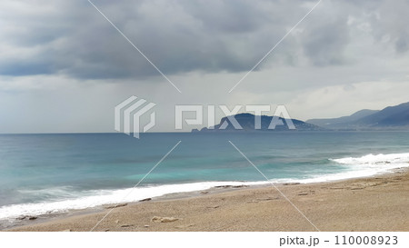 Sea coast, stormy sky over turquoise sea, view from shore. 110008923