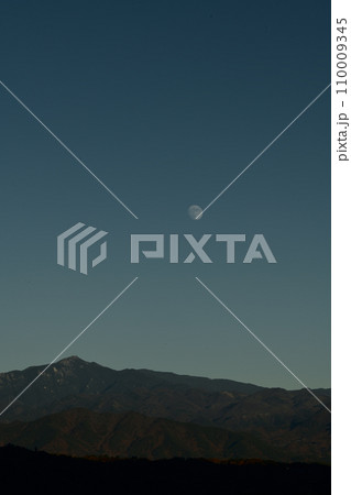 夕空の金峰山の上に昇った月齢11.7の月 110009345