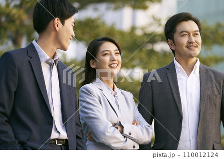 team of three asian businesspeople chatting talking conversing outdoors team of three asian businesspeople chatting talking conversing outdoors 110012124