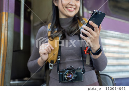 Woman using mobile phone while travel by train. travel concept 110014041