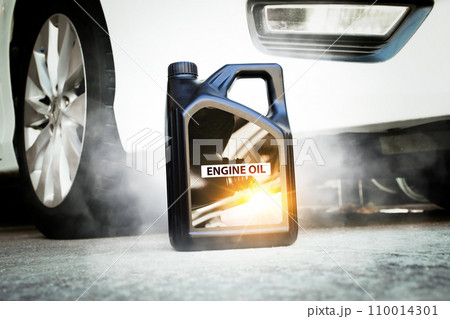 Engine oil or motor oil gallon placed on the road with a car on background , Car maintenance concept Engine oil or motor oil gallon placed on the road with a car on background , Car maintenance concept 110014301