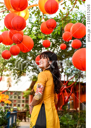 Beautiful Vietnamese woman in traditional vietnamese dress near red lanterns in Tet  Lunar New Year 110015208