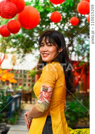 Beautiful Vietnamese woman in traditional vietnamese dress near red lanterns in Tet Lunar New Year Beautiful Vietnamese woman in traditional vietnamese dress near red lanterns in Tet Lunar New Year 110015209