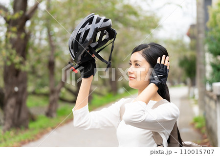 サイクリングヘルメットを被る若い女性 サイクリングヘルメットを被る若い女性 110015707