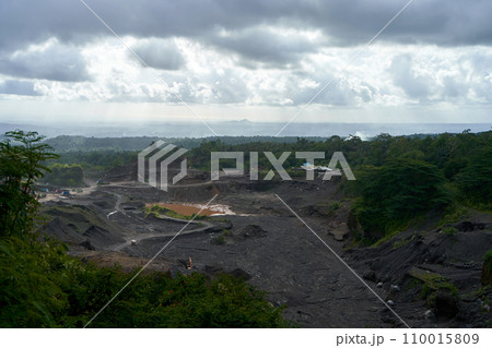 A stone quarry in Indonesia. Large equipment such as bulldozers and dump trucks are working on the site. 110015809