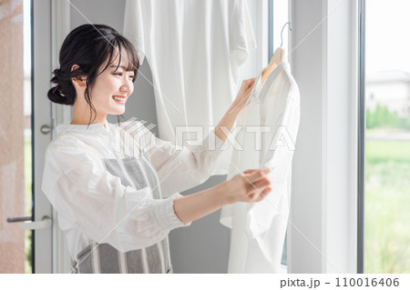 洗濯物を干す女性(家事・主婦・洗剤・柔軟剤・漂白) 洗濯物を干す女性(家事・主婦・洗剤・柔軟剤・漂白) 110016406