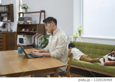 子供のいる自宅で在宅勤務をする30代の男性 110016460